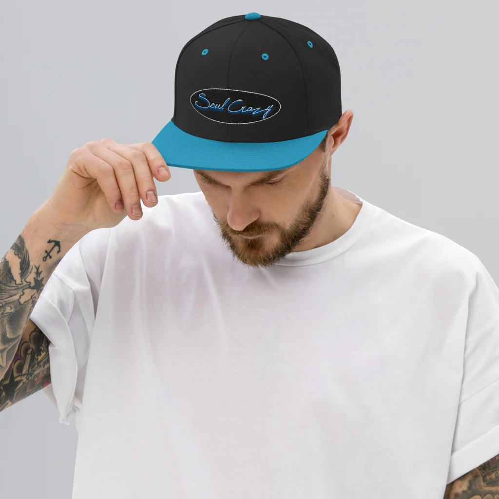 Chico con la gorra snapback negra y turquesa con bordado 3D