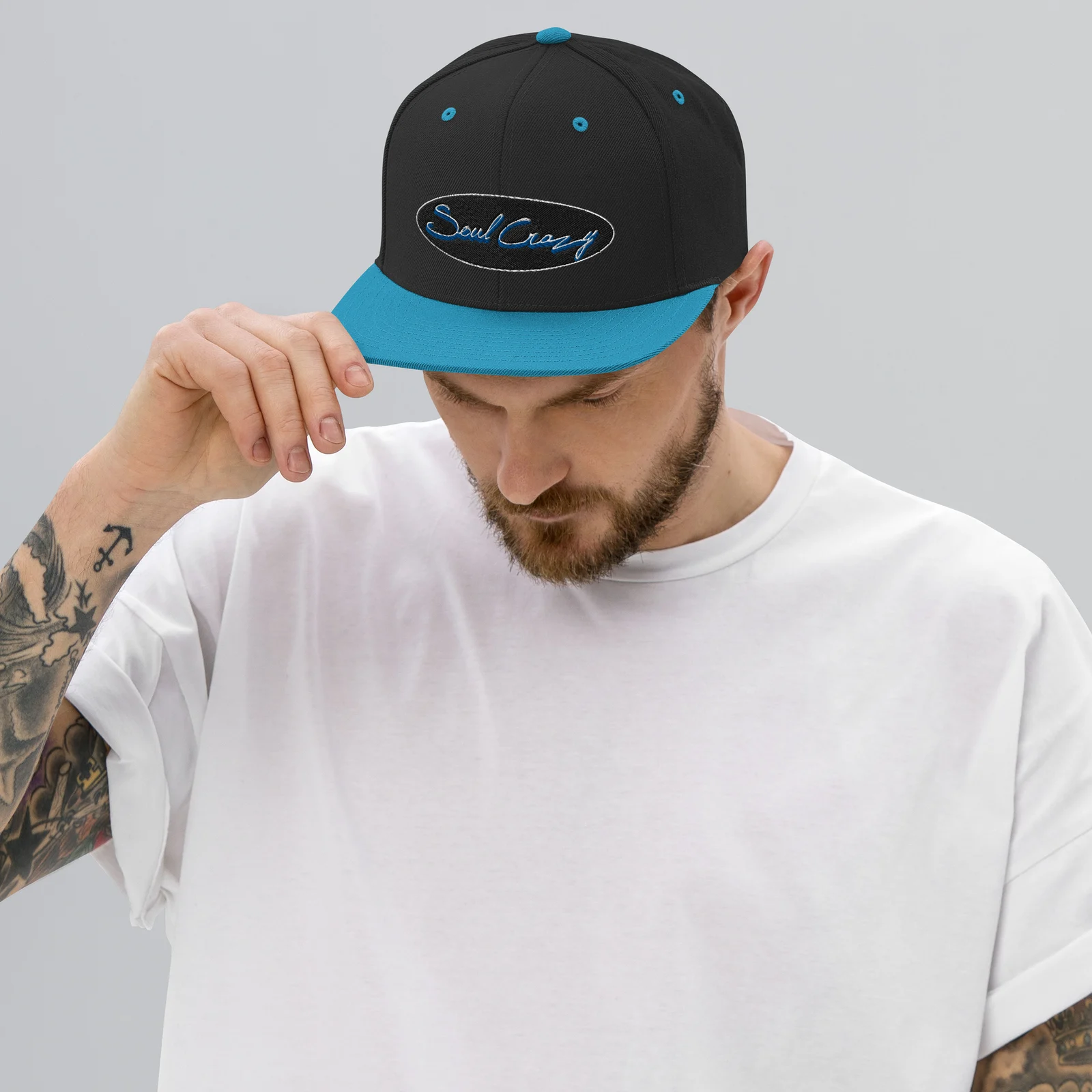 Chico con la gorra snapback negra y turquesa con bordado 3D