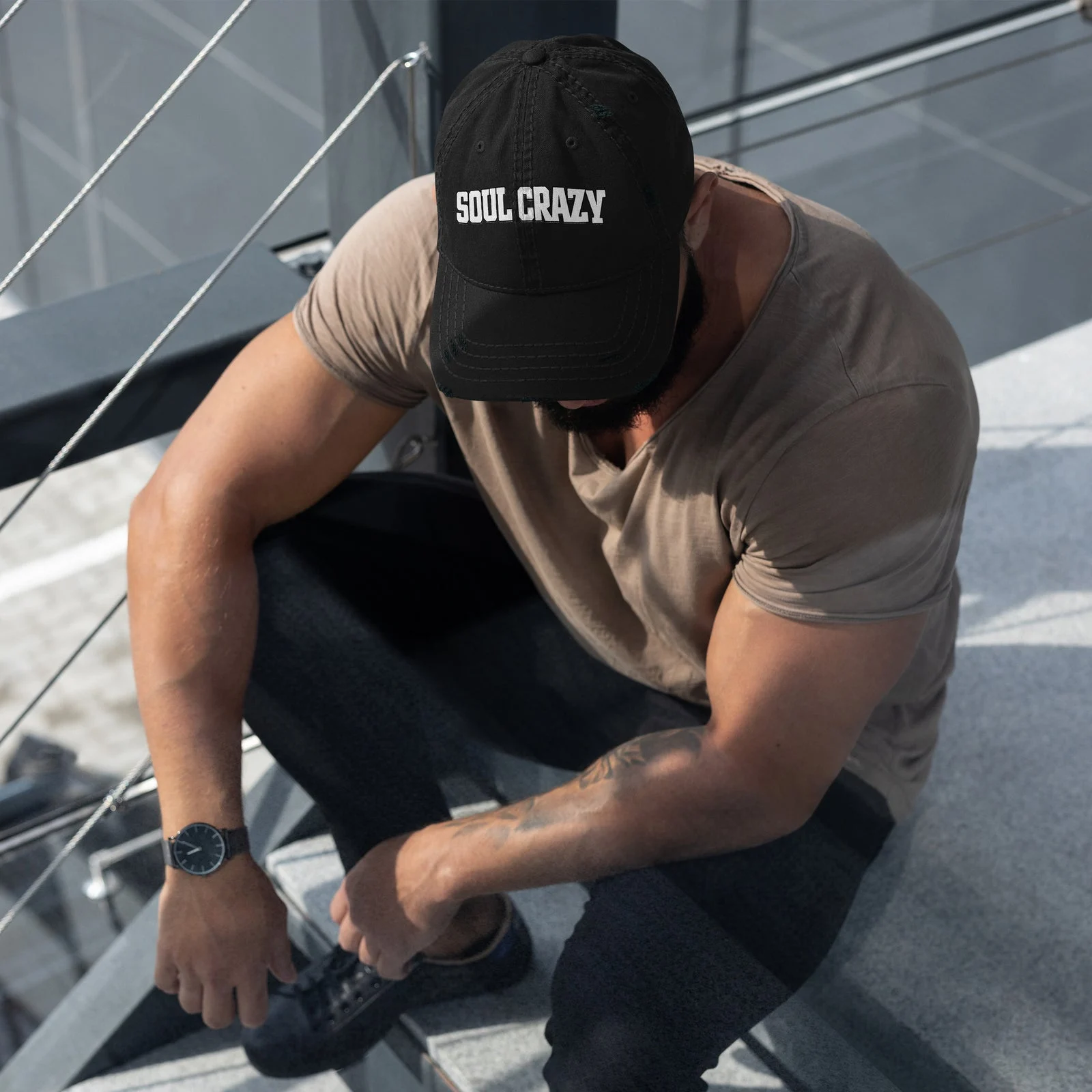 Chico sentado con la gorra negra desgastada con las letras Soul Crazy